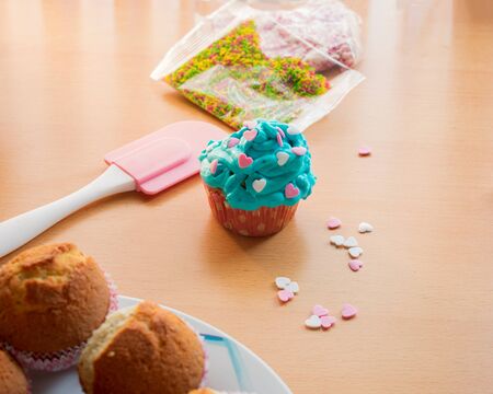 Homemade cupcake with blue cream topping and heartsの写真素材