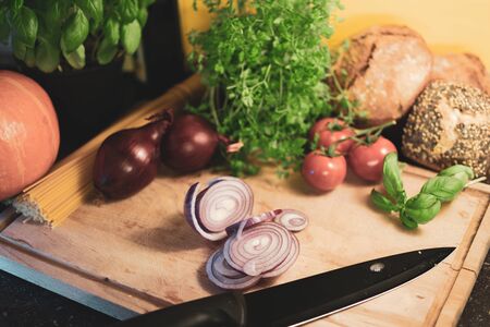 sliced red onion on a wooden board with decoration and cutting knife.の写真素材