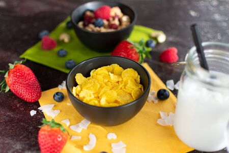 Bowl of delicious cornflakes. Served with coconut milk and muesli blurred
