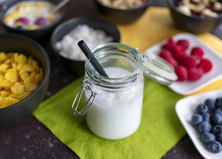delicious coconut milk with coconut flakes in preserving jar with strawの写真素材
