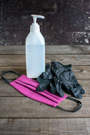 hygiene concept: atomizer, purple face mask and disposable gloves on wood.の写真素材