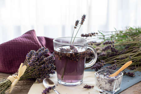 Lavender tea rustic on wood in a glass teacup. Lavender (Lavandula angustifolia), has a calming and antispasmodic effect.の写真素材