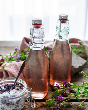 Flowery-scented lavender syrup in preserving bottles filled with lavender sugar.の写真素材