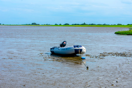 Inflatable boat on the North Sea coast of Burhave in Lower Saxony at low tide in clear, sunny weather.の写真素材