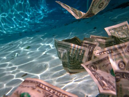 dollars floating in water and the sunlightの写真素材