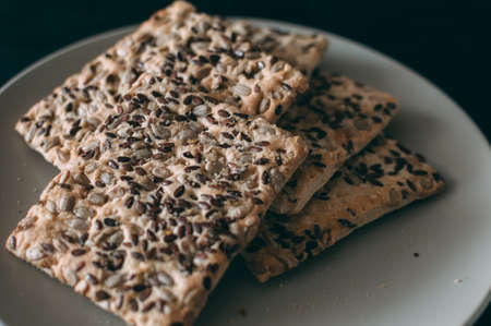 grain biscuits sprinkled with sesame seeds on a wooden backgroundの写真素材