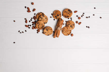 Homemade dessert biscuits on a white wooden background with cinnamon and nuts. Chocolate chip, oatmeal raisin, dough and nuts. Copy text menu food background.の写真素材