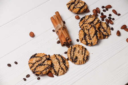 Homemade dessert biscuits on a white wooden background with cinnamon and nuts. Chocolate chip, oatmeal raisin, dough and nuts. Copy text menu food background.の写真素材