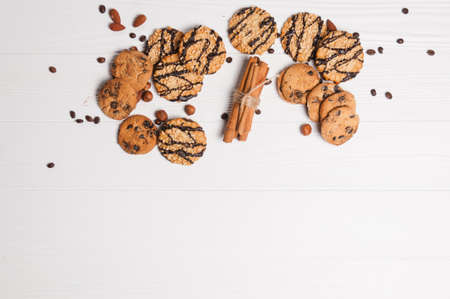 Homemade dessert biscuits on a white wooden background with cinnamon and nuts. Chocolate chip, oatmeal raisin, dough and nuts. Copy text menu food background.の写真素材