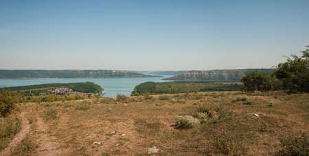 House on the water, against the background of the Dniester and fjords with trees on the shore. Summer evening, evening sunrise. Bakota, Ukraineの写真素材
