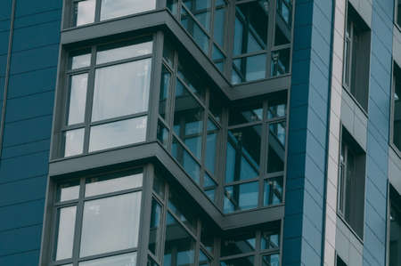 Bottom view of modern skyscrapers in business district against blue skyの写真素材