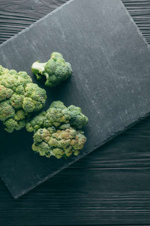 Fresh broccoli on a blackboard against a dark wood background. view from above. place under the text. toningの写真素材