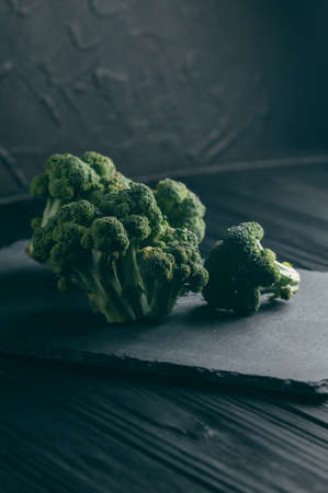 Fresh broccoli on a blackboard against a dark wood background. side view. place under the text. toningの写真素材