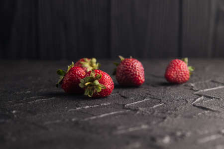 Fresh strawberries in a plate on a black backgroundの写真素材