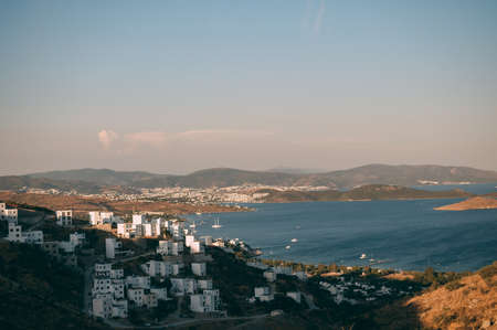 Typical white, cubic Bodrum houses in Turkey with a sea view, during sunset, summer.の写真素材