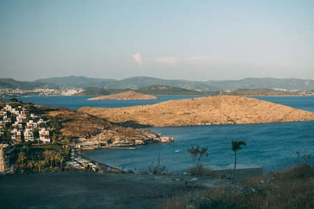 Typical white, cubic Bodrum houses in Turkey with a sea view, during sunset, summer.の写真素材