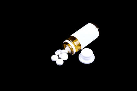 Supplements pills on the table with dose isolated on a black background