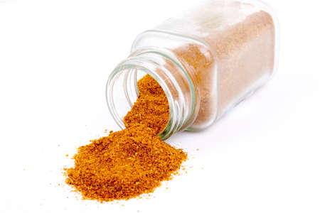 A still life with dried spices spilling from glass jars.の写真素材