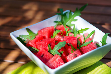 delicious fresh watermelon and arugula salad on wooden tableの写真素材