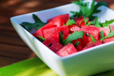 delicious fresh watermelon and arugula salad on wooden tableの写真素材