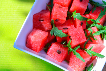 delicious fresh watermelon and arugula salad on wooden tableの写真素材