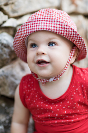 Smiling Cute Baby Girl in chequered hat  - very shallow depth of fieldの写真素材