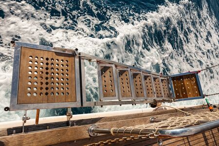 Wooden gangway - trap of a ship over the blue sea