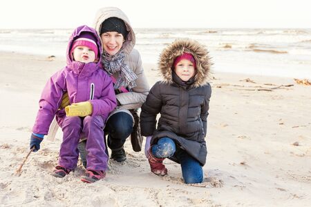 Mother and daughters having fun on the beachの写真素材