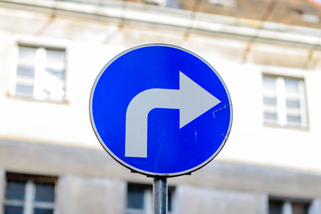 Arrow sign against white building backgroundの写真素材