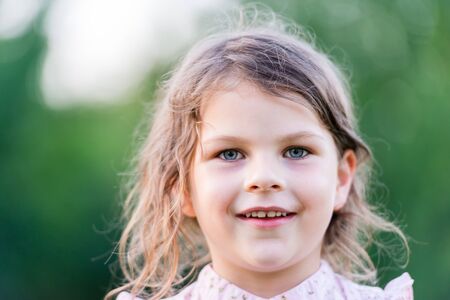 Happy girl excited. Young girl smiling very happy surprised  being amazed on green background. Cute little girl looking at camera. Closeup portrait with shallow depth of field.の写真素材