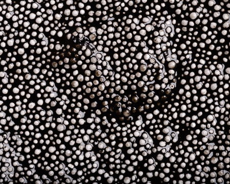 Colorful background - textured black wet plasticine - irregular pattern