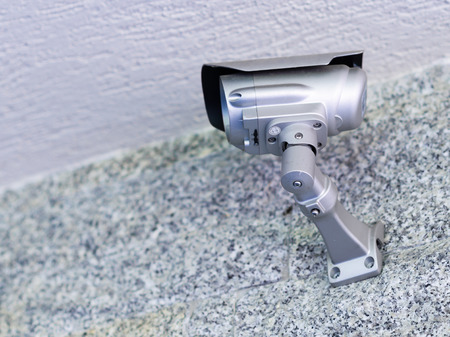Security Camera on a grey stone wall in a Modern Building