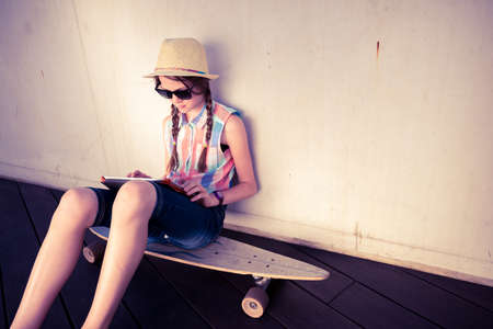 Hipster Girl Skateboarder listening to the music - Relax Lifestyle Concept -  toned with a retro vintage filterの写真素材