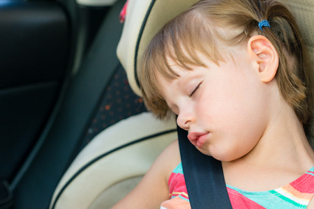 Toddler girl asleep in a child safety seat in a carの写真素材
