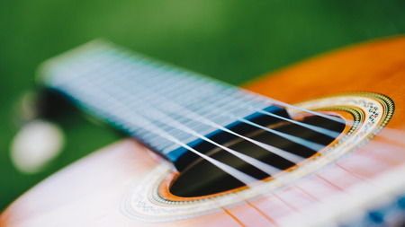 Acoustic guitar bridge and strings close up - macro - very shallow depth of field