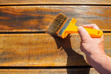 Oiling Terrace with Wide Brush - painting wooden patio deck with protective oil