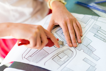 Young girl learning on the course of architectural design for children - preparing architectural modelの写真素材