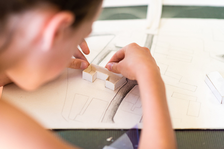 Young girl learning on the course of architectural design for children - preparing architectural modelの写真素材