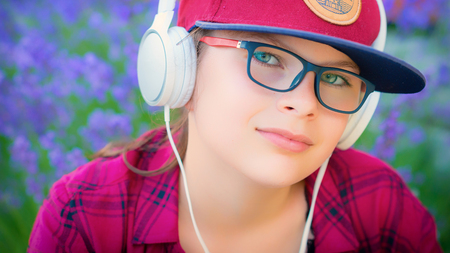 Cute girl listening to music with headphones outdoorの写真素材