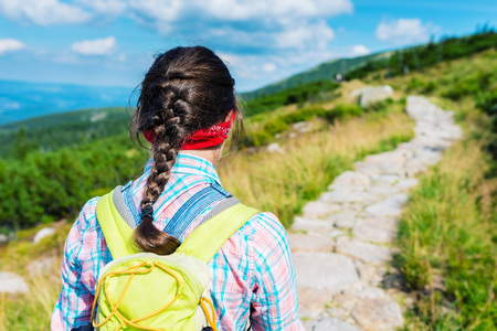 Hiking girl in the mountains - view from behindの写真素材