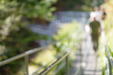 steel suspension footbridge in mountains - image with natural extremely shallow depth of field - ready for backgroundの写真素材