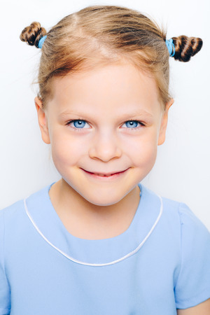 happy little girl with big blue eyes on white background - vintage filter appliedの写真素材