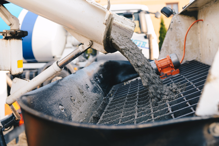 Pouring concrete from a concrete mixer to the pump - pouring concrete slabの写真素材