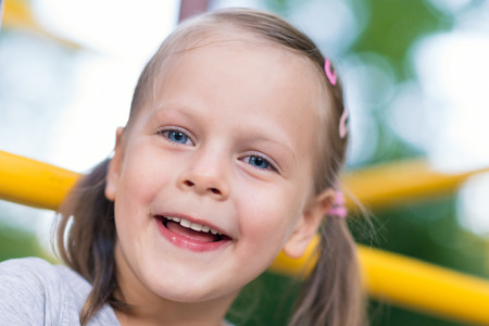 Happy young girl close up portrait outdoors at playground - shallow depth of fieldの写真素材