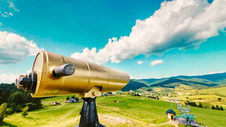 Golden tourist telescope and blurred Pieniny mountains landscape in the backgroundの写真素材