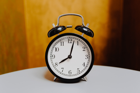 black retro alarm clock on vintage color background