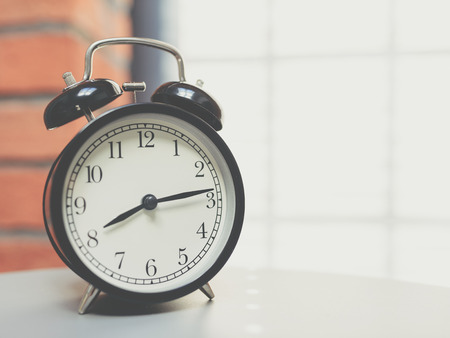 Retro alarm clock on table with vintage backgroundの写真素材