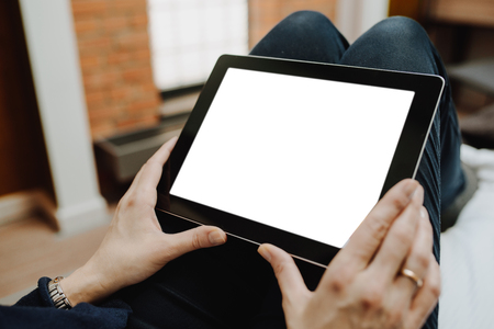 woman using tablet sitting on the bedの写真素材