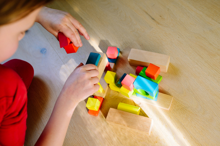 child playing with colorful wooden blocks - view from aboveの写真素材