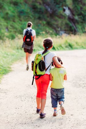 Two little girls during a family trip following their mother on a sunny summer dayの写真素材